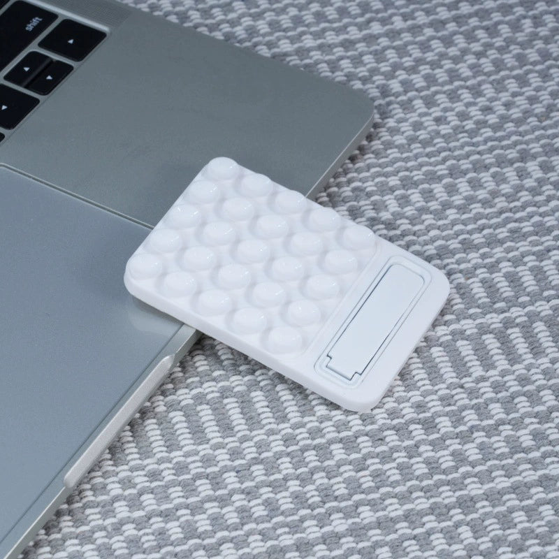 Hvid MagSafe Suction Mobilholder med Kickstand og flere sugekopper monteret bag på laptop